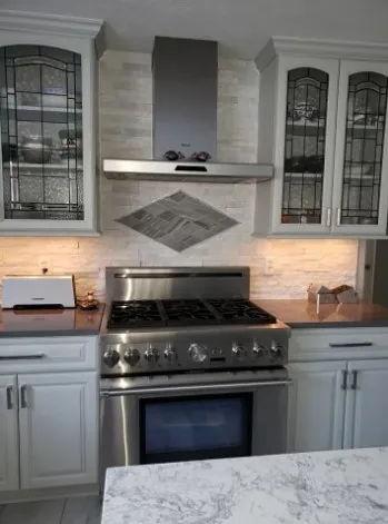 Stone kitchen backsplash with diamond accent behind the range