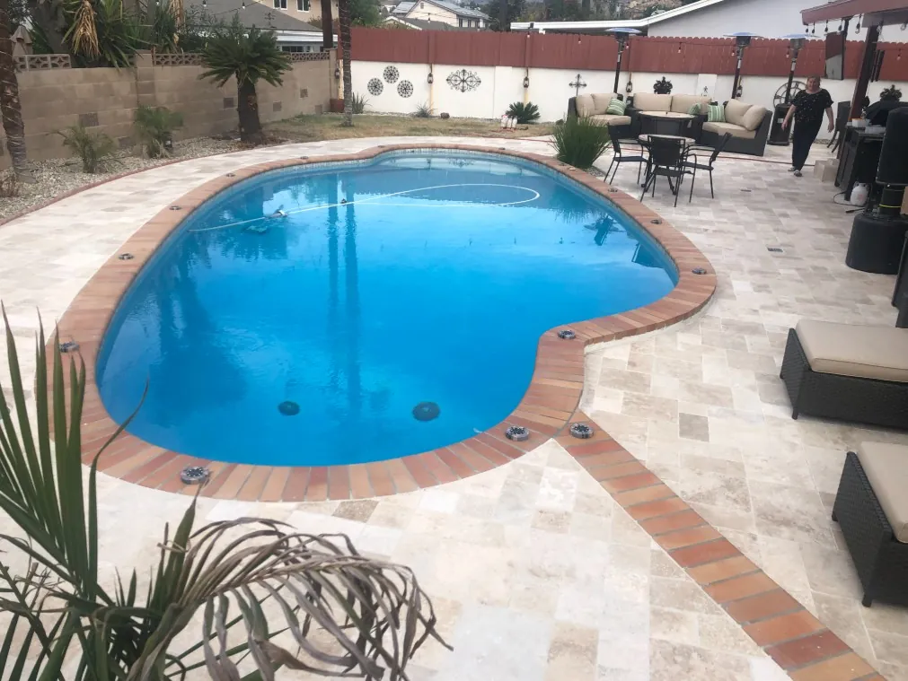 Travertine pool deck with brick coping